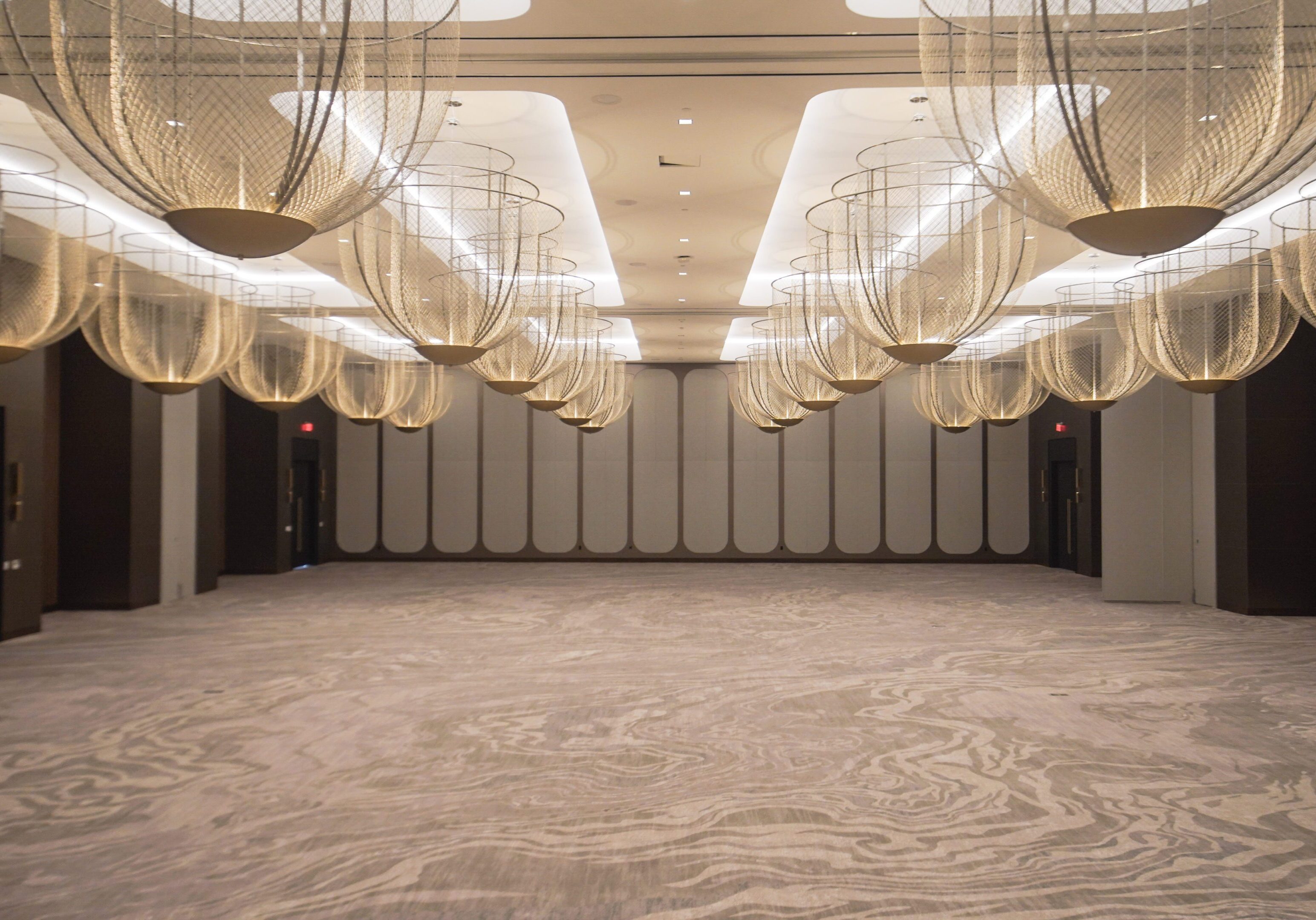 Elegant ballroom with modern spherical chandeliers.